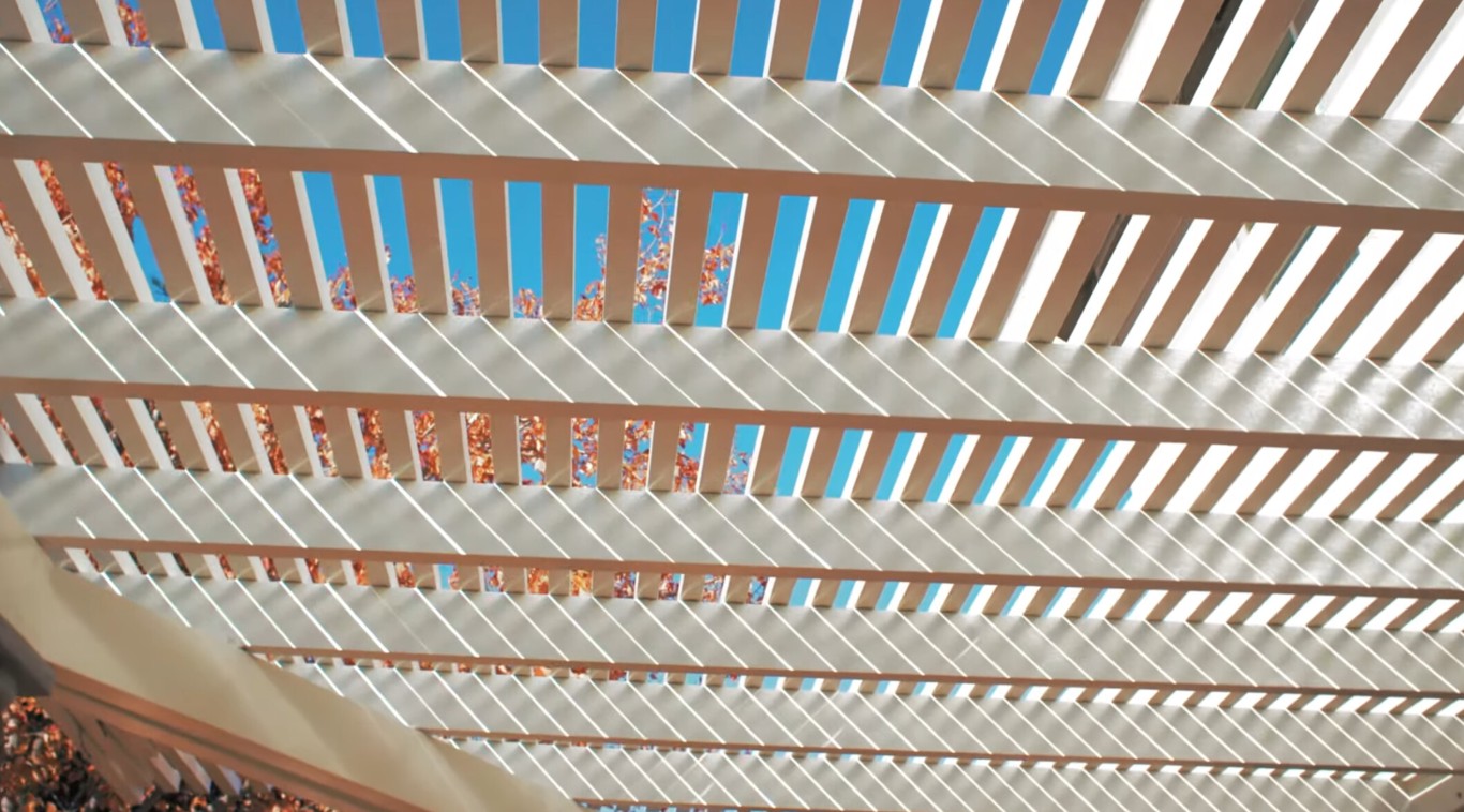 White pergola with decorative slatted ceiling providing shade
